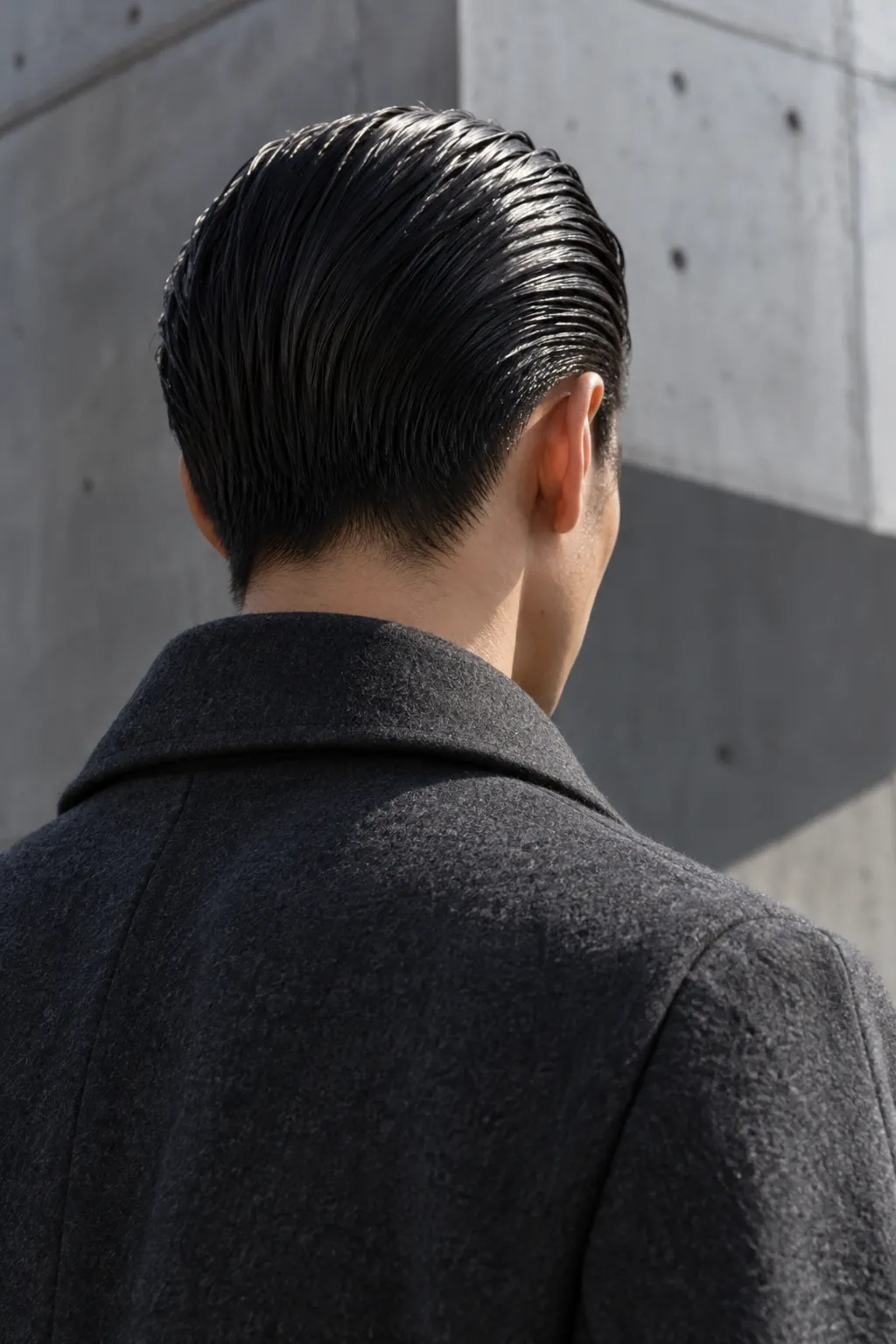 Wet-look hair combed straight back, seen from behind
